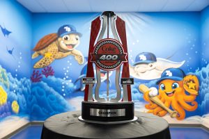 Daytona Coke Zero Sugar 400 champion trophy on a black pedestal, set against a bright blue underwater mural with cartoon sea creatures.